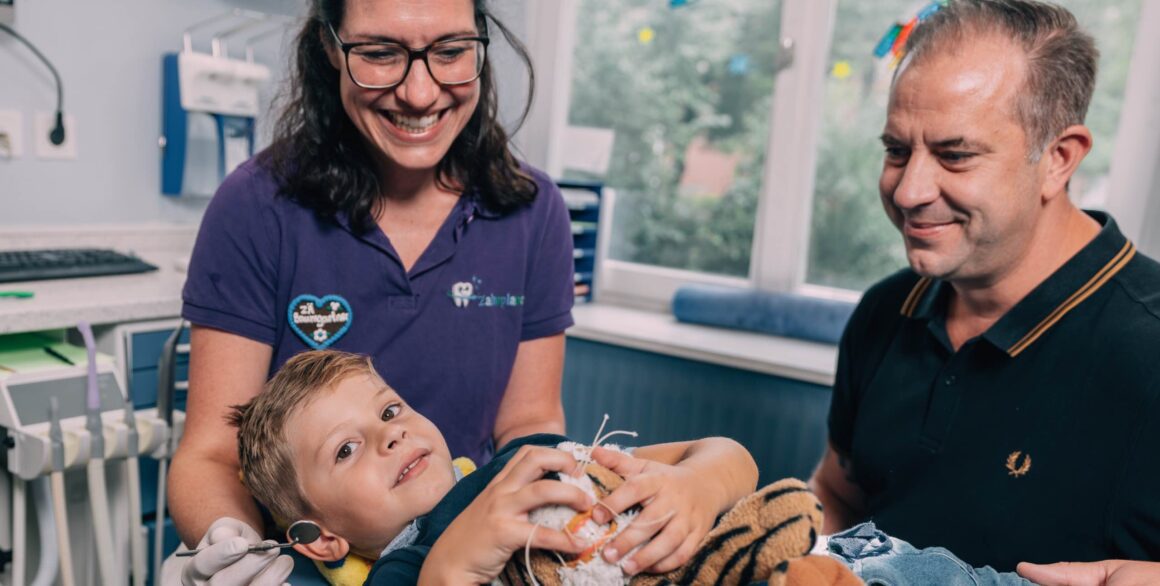 Kind in Behandlung mit Eltern beim Kinderzahnarzt Zahnplanet München-Schwabing