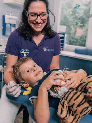 Kind in Behandlung mit Eltern beim Kinderzahnarzt Zahnplanet München-Schwabing