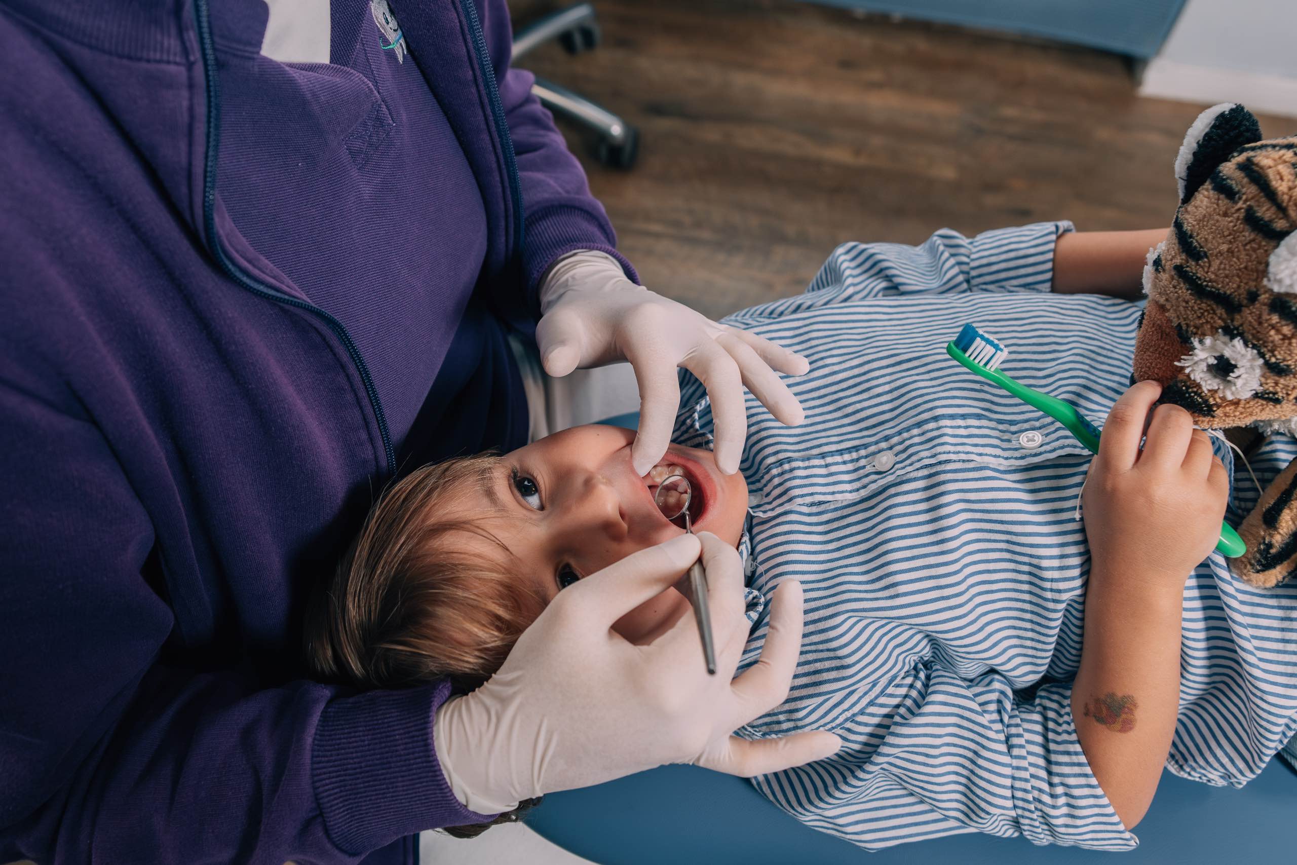 Kind in Behandlung beim Kinderzahnarzt Zahnplanet München-Schwabing mit Kuscheltier