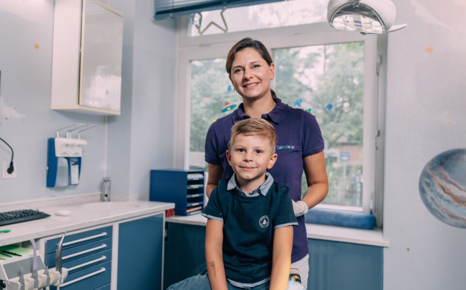 Kind mit Kinderzahnärztin im Behandlungszimmer bei Zahnplanet München-Schwabing